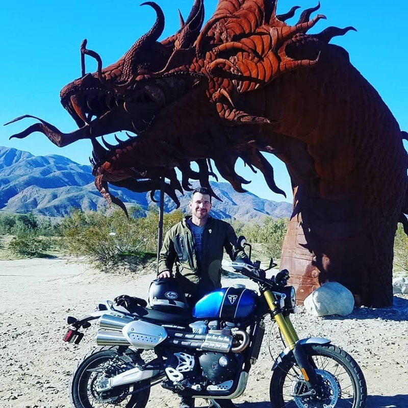 Brent Gyuricza on Triumph motorcycle in front of dragon head